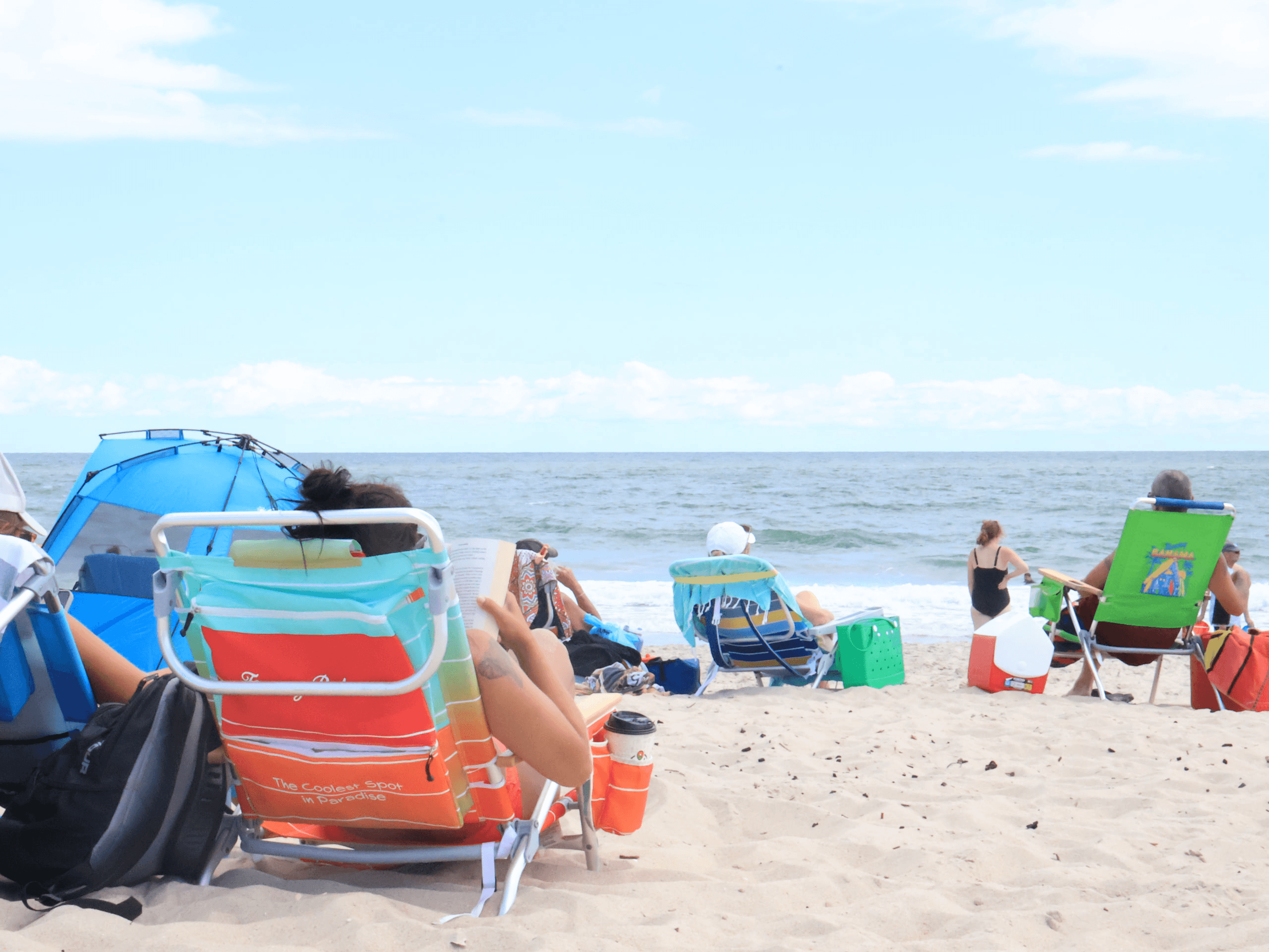 Colorful beach chairs and readers beside the ocean