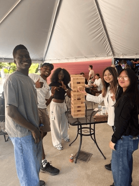 Friends gathered around a giant Jenga game